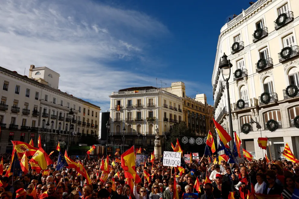 People hold flags as they gather to take part in a protest called for by the Popular Party against a deal reached by Spains socialists with the Catalan separatist Junts party for government support, which involves amnesties for people involved with Catalonias failed 2017 independence bid, in Madrid, Spain November 12, 2023. REUTERS/Susana Vera [[[REUTERS VOCENTO]]] SPAIN-POLITICS/PROTESTS