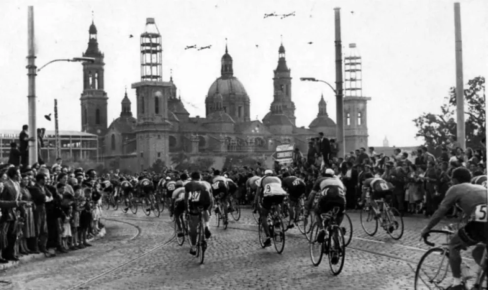 Zaragoza recibe a los ciclistas de la Vuelta a España el día 7 de mayo de 1956. Al fondo, dos de las torres del Pilar todavía en obras. Foto de Martín Chivite
