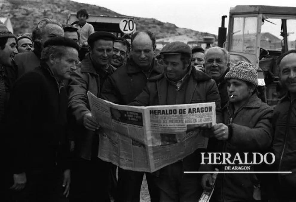Unos agricultores afectados por la guerra de los precios del maíz leyendo HERALDO DE ARAGÓN para informarse sobre la 'tractorada' que realizaron en enero de 1976 en la provincia de Zaragoza, en un año donde aumentó notablemente el número de huelguistas y paros.