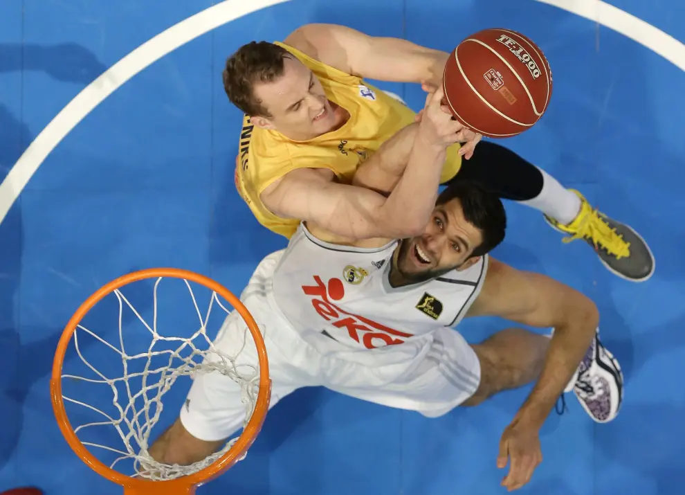 Dos jugadores compiten por el balón en un partido de baloncesto.