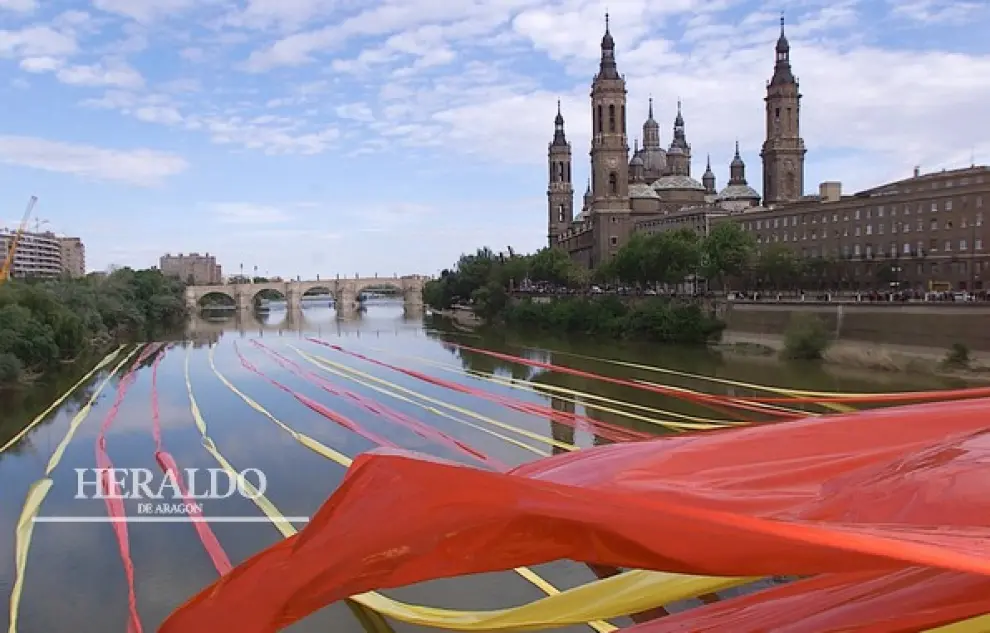 Varias tiras con los colores de la bandera de Aragón 'abrazan' al río Ebro entre los puentes de Santiago y de Piedra durante el Día de Aragón de 2001