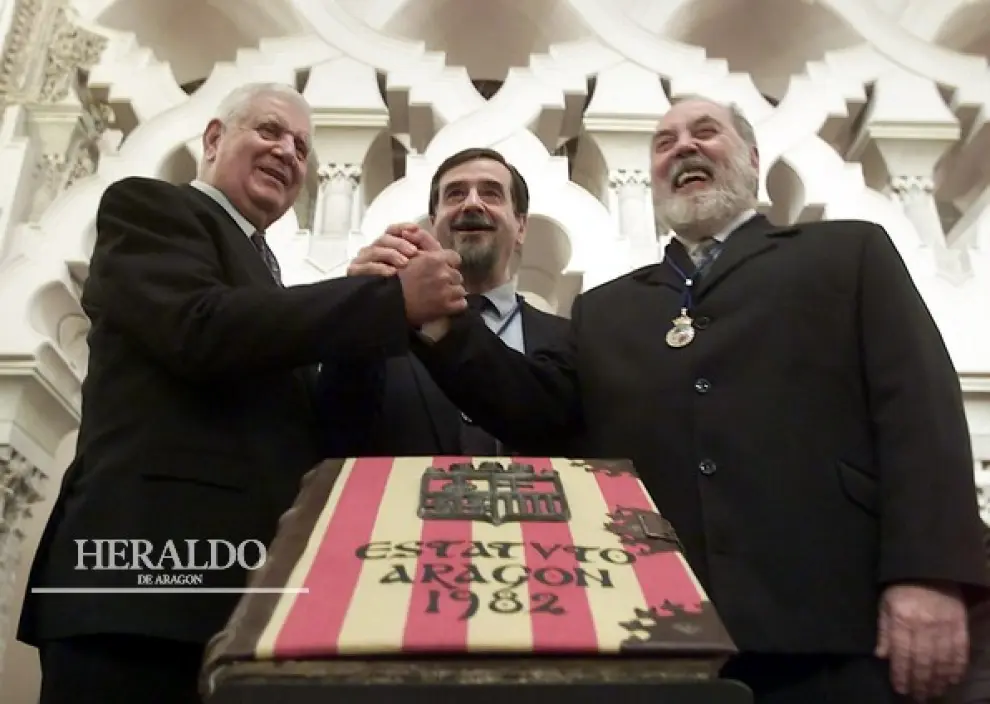 Los tres galardonados con las Medallas de Oro 2002 de la DGA posan ante un ejemplar del Estatuto: Juan Antonio Bolea Foradada (primer presidente de la DGA), Antonio Embid Irujo (primer presidente de las Cortes) y Emilio Gastón (primer Justicia)