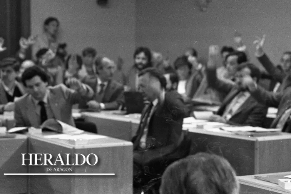 El 20 de mayo de 1983 quedan constituidas las primeras Cortes de Aragón. La foto, posterior, muestra el momento de un pleno, celebrado en los sótanos de la entonces Cámara Provincial de Comercio de Zaragoza. En el centro de la imagen, Santiago Marraco