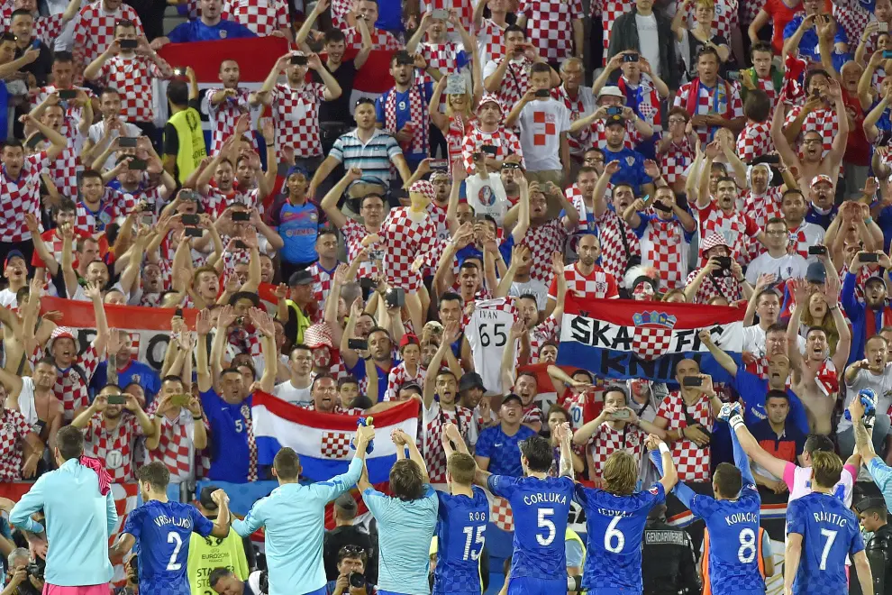 Los jugadores croatas celebran la victoria con sus aficionados en una zona cercana a la de los turolenses