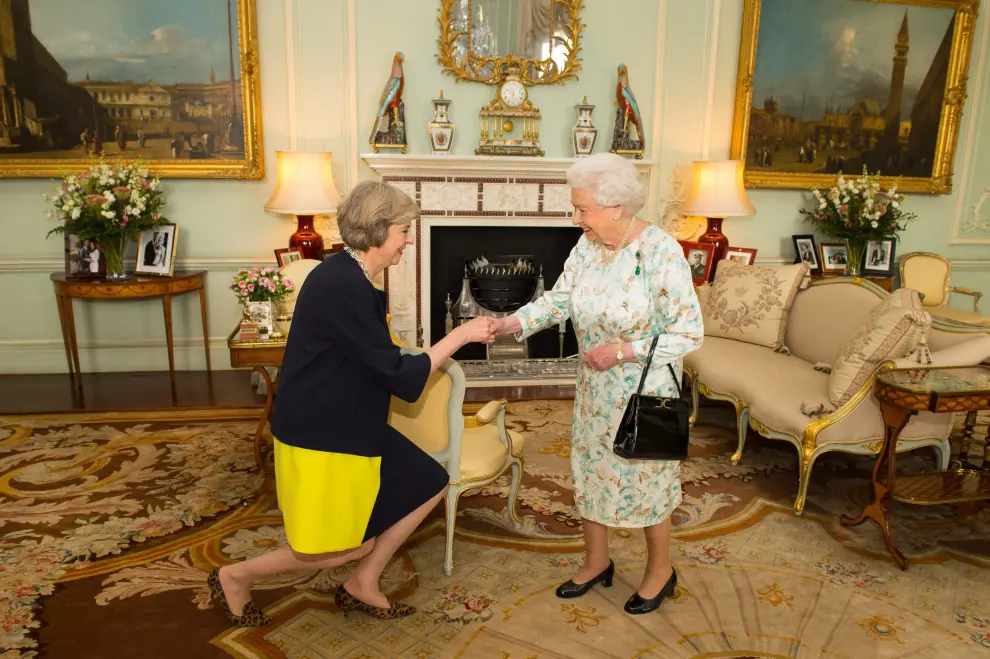 Theresa May saludando a la reina Isabel II.