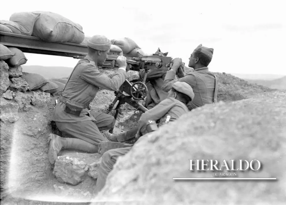 Soldados del bando franquista manejando una ametralladora en una trinchera.