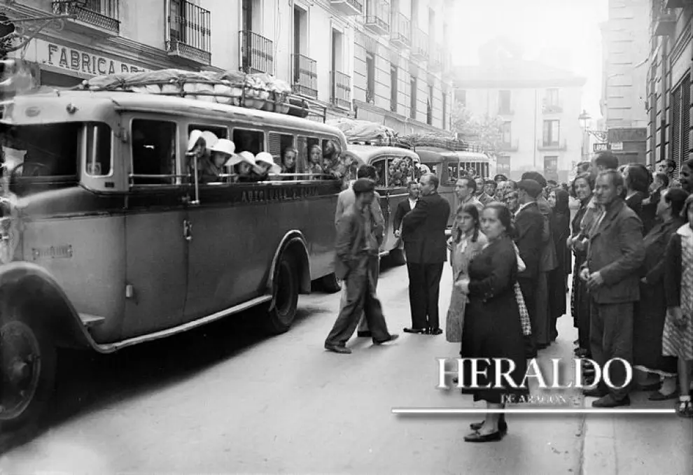 Salida de los autocares desde Zaragoza con los niños que integran la colonia escolar organizada por el Monte de Piedad en julio de 1935. En la fotografía, los familiares despiden a los niños.