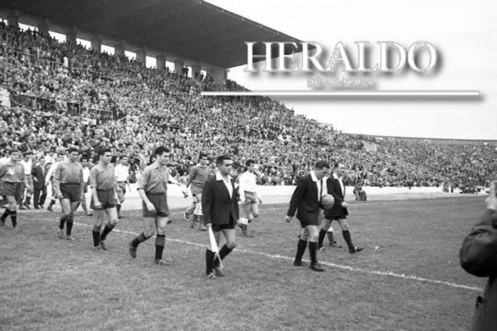 Inicial desfile de los equipos en la tarde la inauguración del campo de la Romareda el 8 de septiembre de 1957. El partido de estreno es un amistoso entre el Real Zaragoza y el Club Atlético Osasuna en la que el Zaragoza ganó por 4-3, con goles locales de Vila (2), Murillo y Wilson.