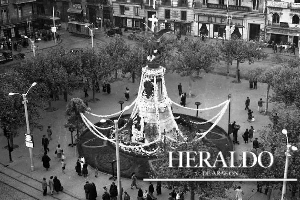 Fotografía de los años 50 con el Monumento a los Mártires, en la plaza de España de Zaragoza, adornado con flores y una cruz como todos los 2 de noviembre, día de los Fieles Difuntos. Fotografía incluida en el coleccionable 'Cómo hemos cambiado' que HERALDO DE ARAGÓN regala en los meses de octubre y noviembre a sus lectores.