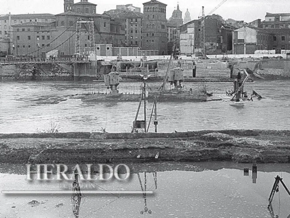 Esta fotografía de 1966 muestra cómo una de las riadas del Ebro de aquel año se llevó por delante el trabajo de todo un mes en la construcción del puente de Santiago. Fotografía incluida en el coleccionable 'Cómo hemos cambiado' que HERALDO DE ARAGÓN está regalando a sus lectores