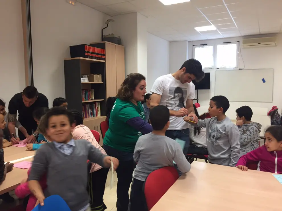Visita de dos jugadores del Huesca a los niños de la Asociación Ymca