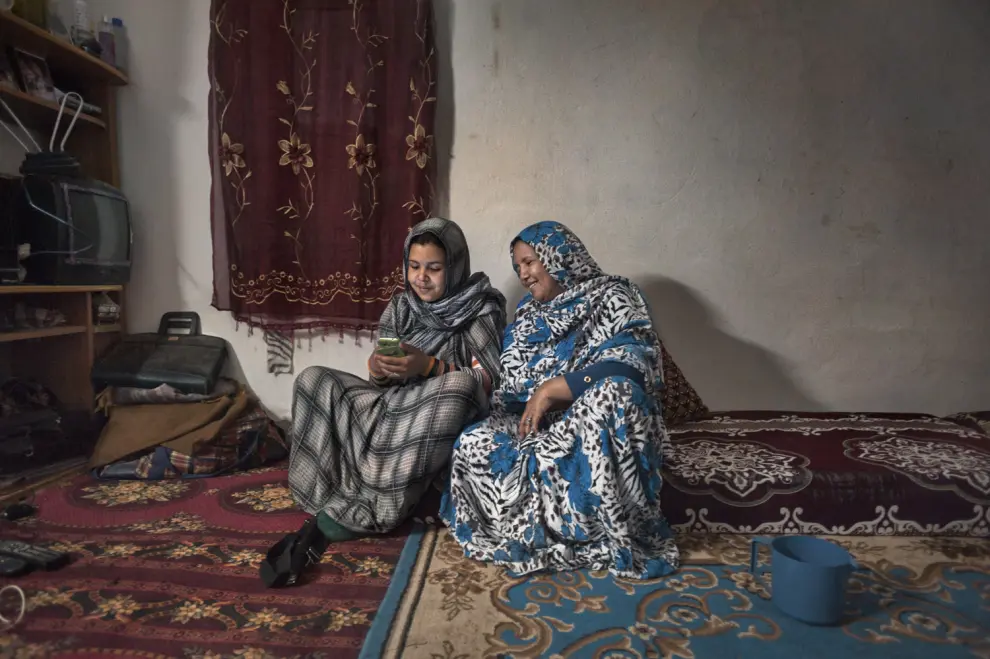 Una madre y su hija se entretienen con su teléfono. Smara, marzo de 2016.