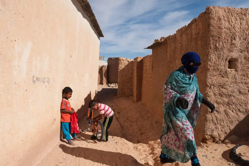 Niños y mujer entre casas de adobe. Bojador, marzo de 2016