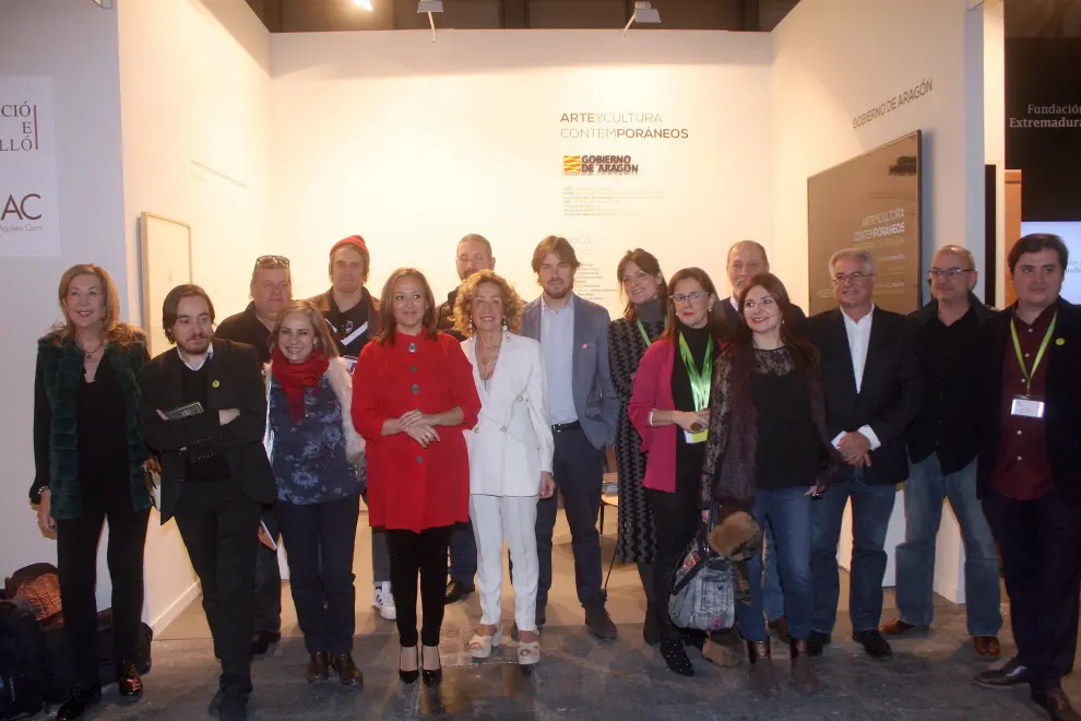 Foto de familia de artistas, galeristas, directores museos y la  consejera delante stand de Aragón.