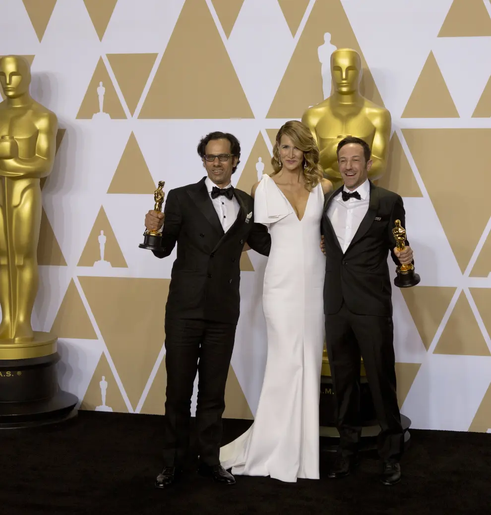 Dan Cogan, a la izquierda, y el director Bryan Fogel posan con su premio a mejor película documental por 'Icarus' junto a la actriz Laura Dern.