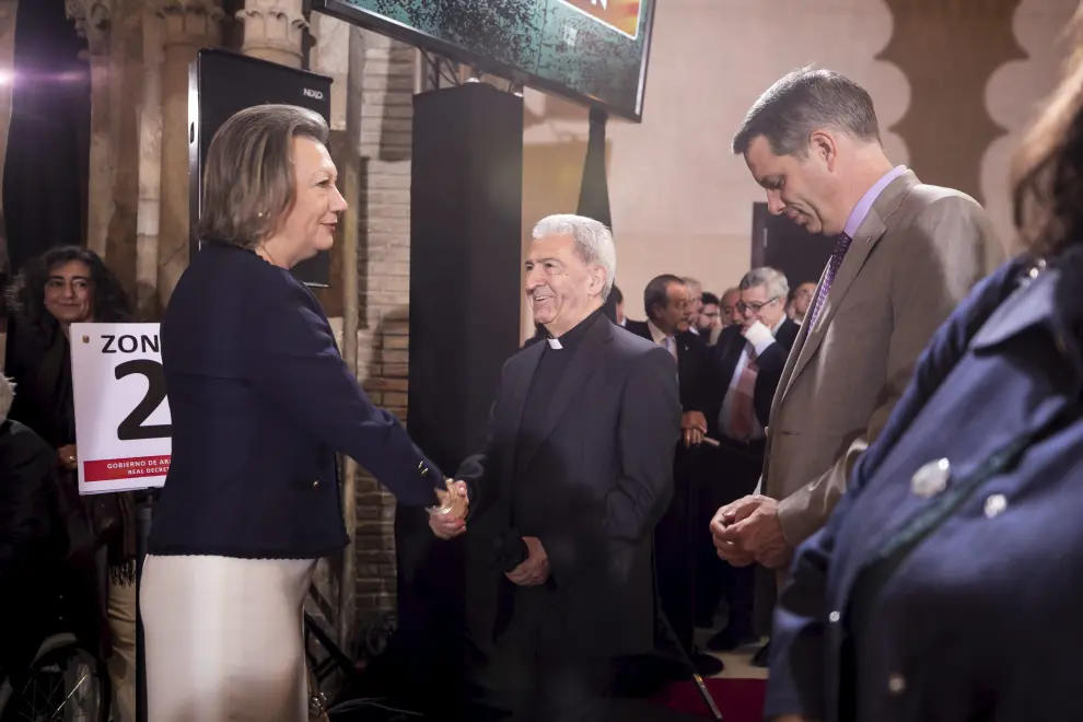 La expresidenta del Gobierno de Aragón, Luisa Fernanda Rudi, da la mano al vicario general de la Archidiócesis de Zaragoza, Manuel Almor.