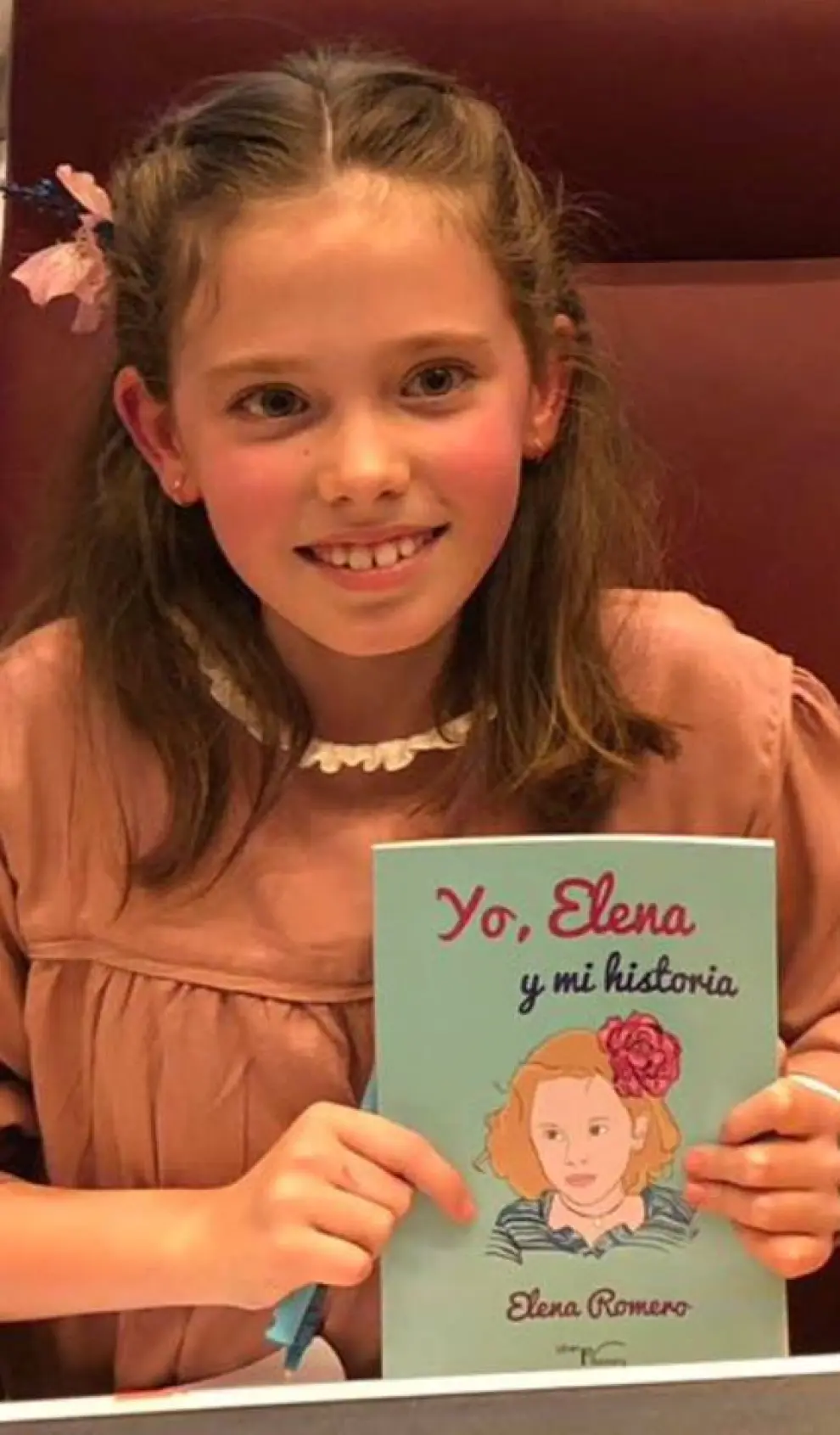 La pequeña Elena, una madrileña de 8 años, con el libro creado para dar a conocer la enfermedad y recaudar fondos para investigar.