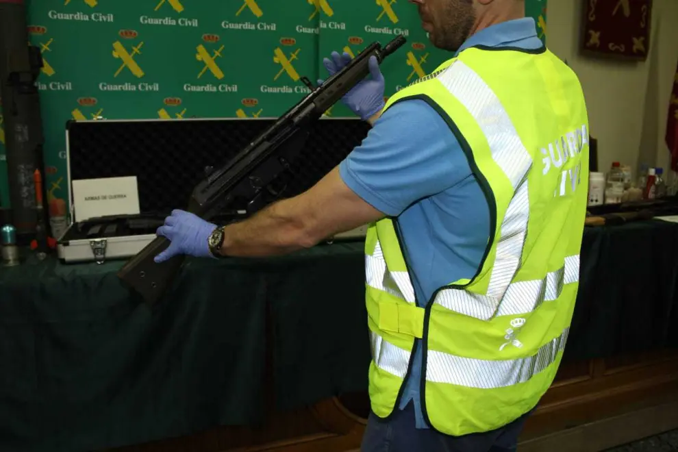Un agente muestra una de las armas intervenidas durante el registro.