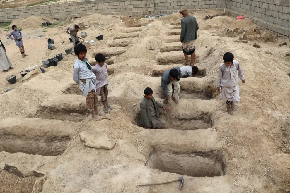 Varios niños inspeccionan las tumbas preparadas para las víctimas del ataque del pasado jueves en Yemen.