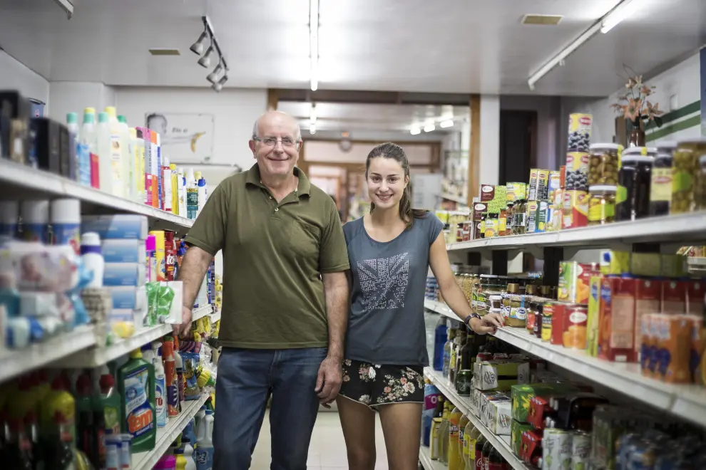 Carlos Armengod y su hija Victoria, en su tienda-supermercado de la plaza
