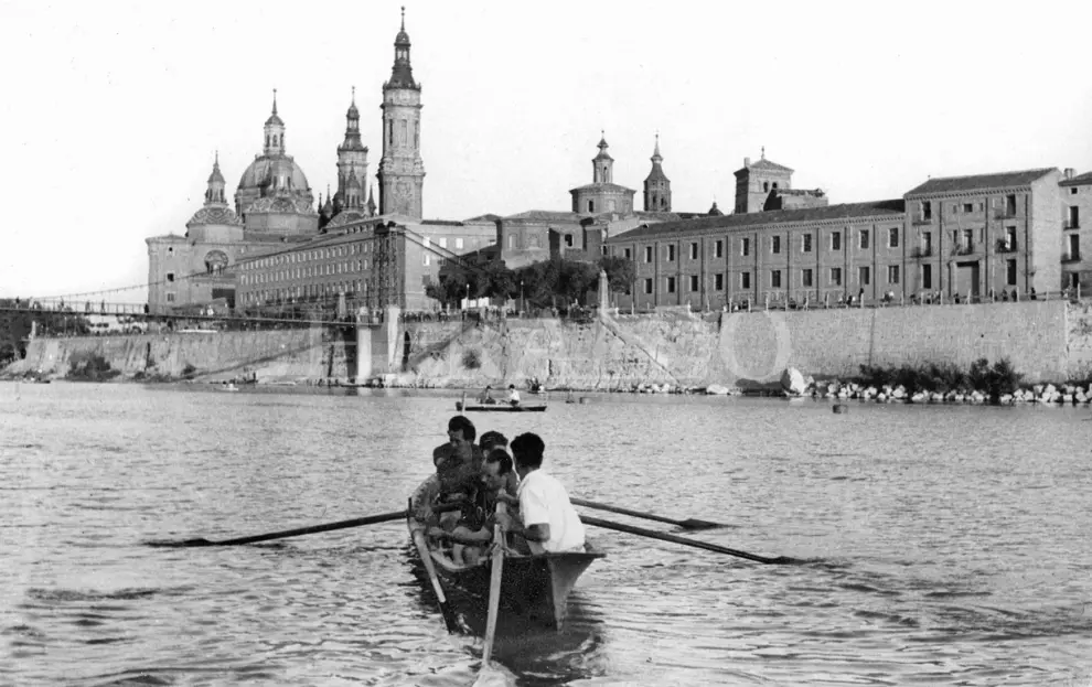 Una barca navegando en el río Ebro de Zaragoza, el 12 de julio de 1948. Detrás, la pasarela sobre el Ebro y el Pilar