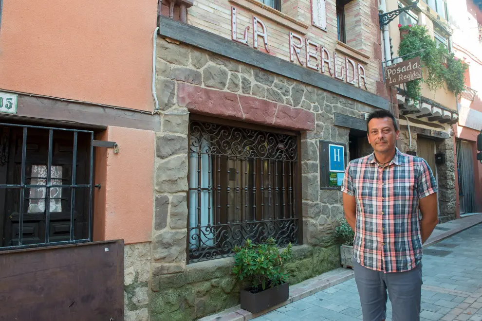 Santiago Rodríguez, gerente del Hotel La Realda con su establecimiento hotelero detrás