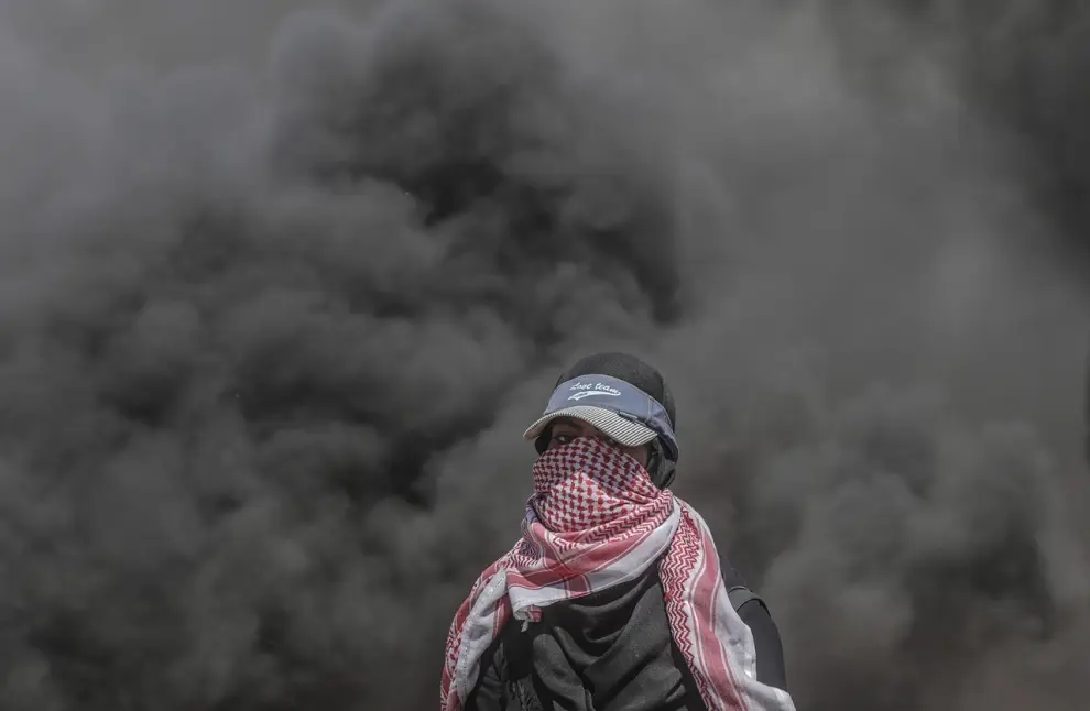 14 DE MAYO. Una manifestante palestina participa en los enfrentamientos tras las protestas convocadas cerca de la frontera con Israel en el este de la franja de Gaza