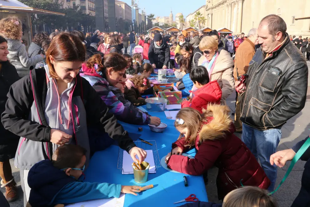 Los más pequeños depositan sus cartas en la plaza del Pilar y escriben sus deseos en el taller navideño