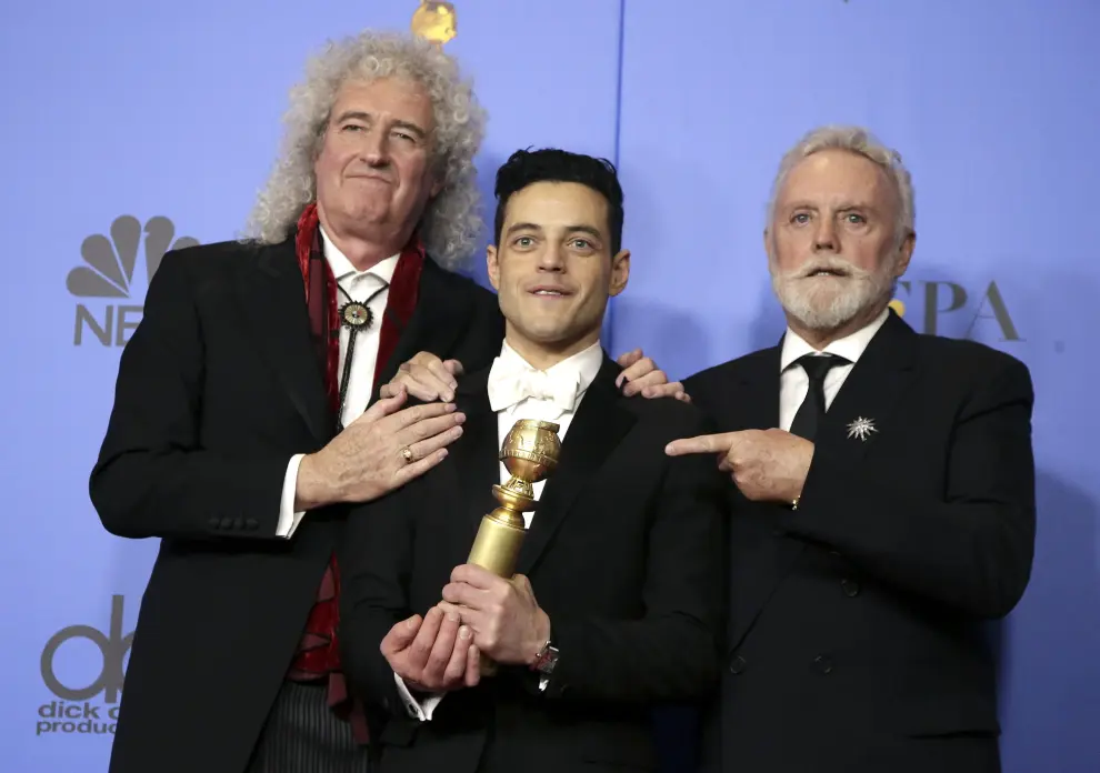 Rami Malek (en el centro) posa con Roger Taylor y Brian May, de Queen, en la Gala de entrega de la 76 edición de los Globos de Oro