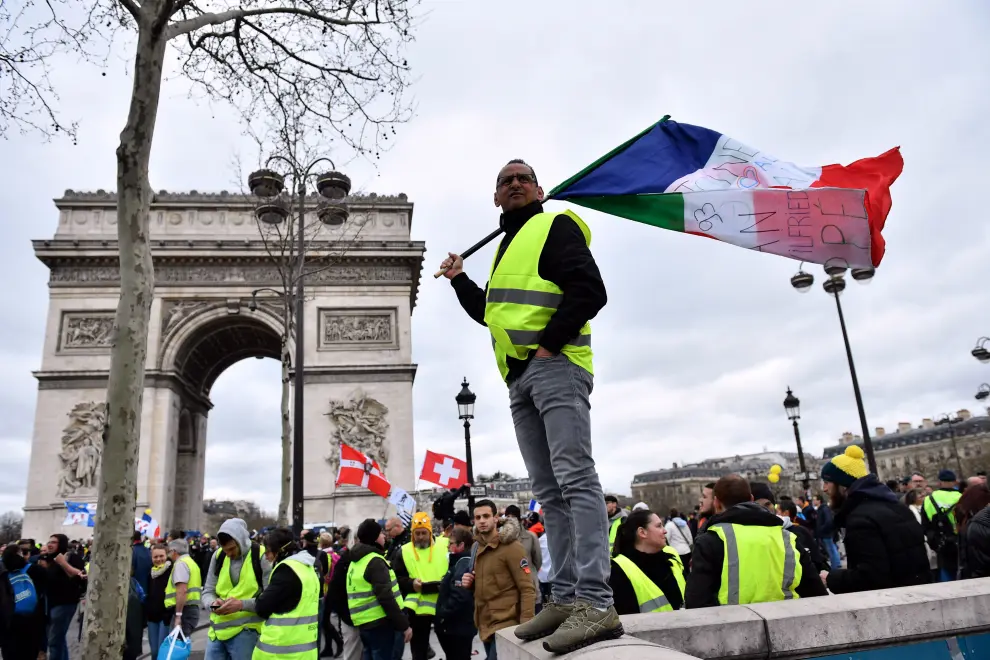 Paris (France), 16/03/2019.- Protesters from the 'Gilets Jaunes' (Yellow Vests) face the police forces as clashes erupt at the Champs Elysees during the 'Act XVIII' demonstration (the 18th consecutive national protest on a Saturday) in Paris, France, 16 March 2019. The so-called 'gilets jaunes' (yellow vests) is a grassroots protest movement with supporters from a wide span of the political spectrum, that originally started with protest across the nation in late 2018 against high fuel prices. The movement in the meantime also protests the French government's tax reforms, the increasing costs of living and some even call for the resignation of French President Emmanuel Macron (Protestas, Francia) EFE/EPA/JULIEN DE ROSA Yellow vests protest against police violence in Paris