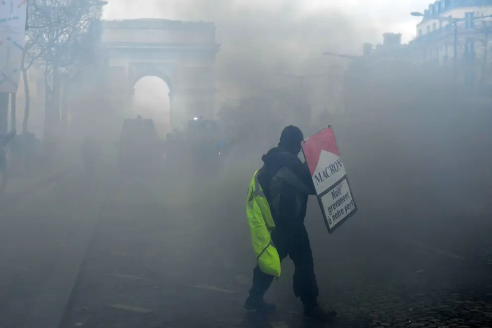 Paris (France), 16/03/2019.- A protester from the 'Gilets Jaunes' (Yellow Vests) holds a french flag in front of the Arc de Triomphe during the 'Act XVIII' demonstration (the 18th consecutive national protest on a Saturday) in Paris, France, 16 March 2019. The so-called 'gilets jaunes' (yellow vests) is a grassroots protest movement with supporters from a wide span of the political spectrum, that originally started with protest across the nation in late 2018 against high fuel prices. The movement in the meantime also protests the French government's tax reforms, the increasing costs of living and some even call for the resignation of French President Emmanuel Macron (Protestas, Francia) EFE/EPA/JULIEN DE ROSA Yellow vests protest against police violence in Paris