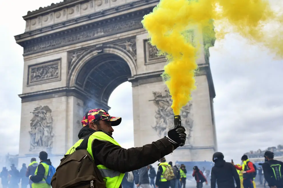 Paris (France), 16/03/2019.- Protesters from the 'Gilets Jaunes' (Yellow Vests) face the police forces as clashes erupt at the Champs Elysees during the 'Act XVIII' demonstration (the 18th consecutive national protest on a Saturday) in Paris, France, 16 March 2019. The so-called 'gilets jaunes' (yellow vests) is a grassroots protest movement with supporters from a wide span of the political spectrum, that originally started with protest across the nation in late 2018 against high fuel prices. The movement in the meantime also protests the French government's tax reforms, the increasing costs of living and some even call for the resignation of French President Emmanuel Macron (Protestas, Francia) EFE/EPA/JULIEN DE ROSA EPA-EFE/JULIEN DE ROSA Yellow vests protest against police violence in Paris