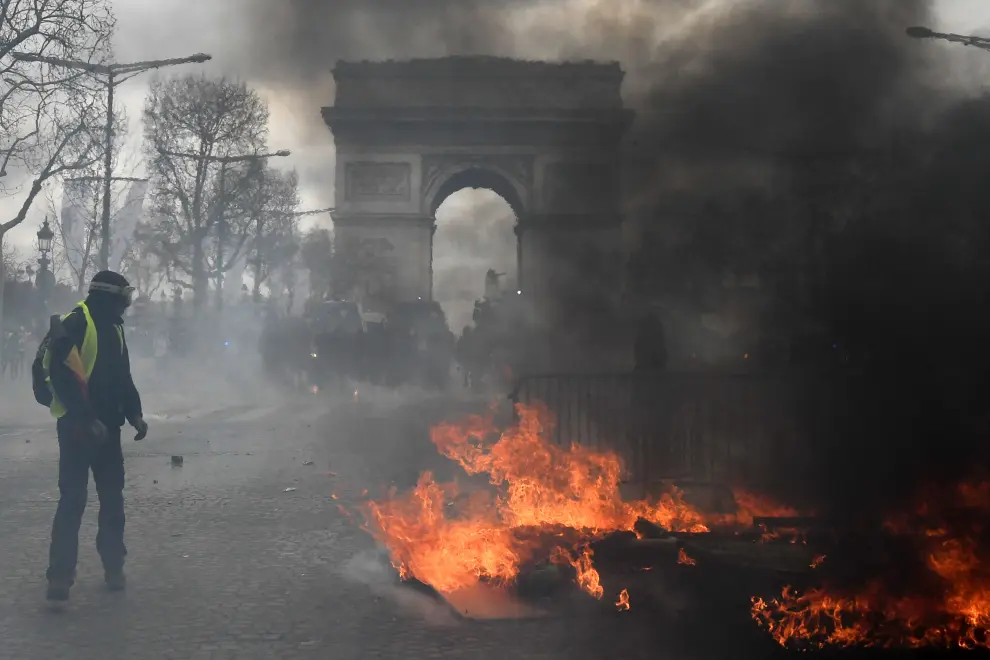 Paris (France), 16/03/2019.- Protesters from the 'Gilets Jaunes' (Yellow Vests) face the police forces as clashes erupt at the Champs Elysees during the 'Act XVIII' demonstration (the 18th consecutive national protest on a Saturday) in Paris, France, 16 March 2019. The so-called 'gilets jaunes' (yellow vests) is a grassroots protest movement with supporters from a wide span of the political spectrum, that originally started with protest across the nation in late 2018 against high fuel prices. The movement in the meantime also protests the French government's tax reforms, the increasing costs of living and some even call for the resignation of French President Emmanuel Macron (Protestas, Francia) EFE/EPA/JULIEN DE ROSA Yellow vests protest against police violence in Paris