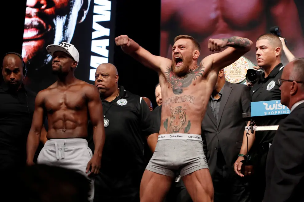 FILE PHOTO: Undefeated boxer Floyd Mayweather Jr. (L) of the U.S. and UFC lightweight champion Conor McGregor of Ireland face off during their official weigh-in at T-Mobile Arena in Las Vegas, Nevada, U.S. on August 25, 2017. REUTERS/Steve Marcus/File Photo [[[REUTERS VOCENTO]]] MMA-MCGREGOR/RETIREMENT