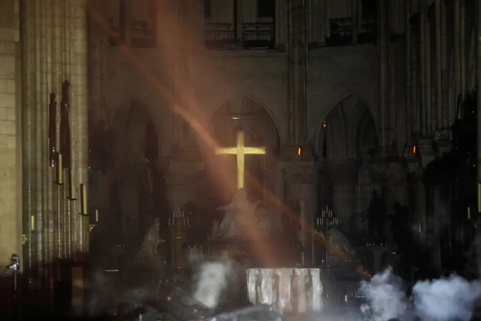 Smoke rises around the alter in front of the cross inside the Notre Dame Cathedral as a fire continues to burn in Paris, France, April 16, 2019.   REUTERS/Philippe Wojazer/Pool [[[REUTERS VOCENTO]]] FRANCE-NOTREDAME/