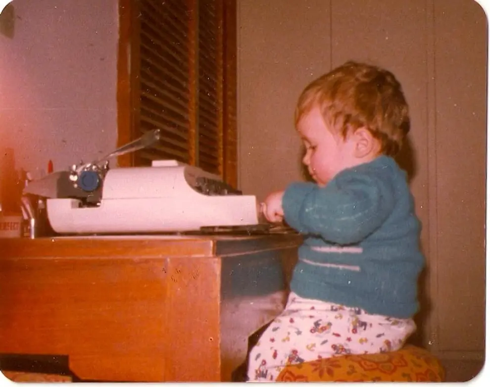 Foto de infancia, junto a una máquina de escribir que le gustaba mucho