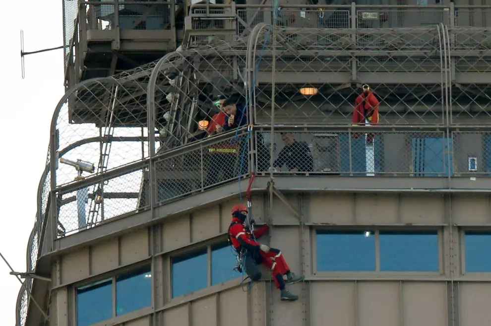 Paris fire brigade specialists sit close to an unidentified man climbing the Eiffel Tower, which had to be evacuated, in Paris, France, May 20, 2019. REUTERS/Charles Platiau [[[REUTERS VOCENTO]]] FRANCE-EIFFELTOWER/