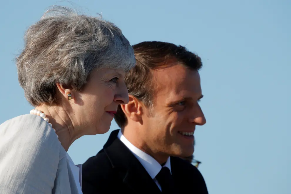 British Prime Minister Theresa May welcomes French President Emmanuel Macron to attend a Franco-British ceremony to mark the 75th anniversary of D-Day landings and laying the first stone of a British memorial at Ver-Sur-Mer, France, June 6, 2019. REUTERS/Philippe Wojazer/Pool [[[REUTERS VOCENTO]]] DDAY-ANNIVERSARY/UK-FRANCE