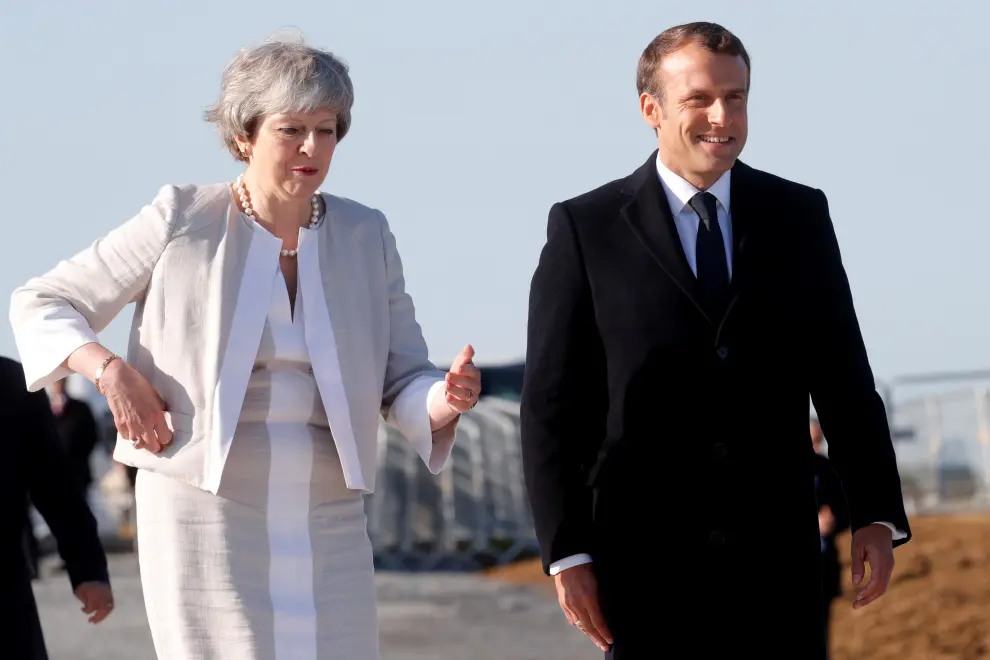 British Prime Minister Theresa May welcomes French President Emmanuel Macron to attend a Franco-British ceremony to mark the 75th anniversary of D-Day landings and laying the first stone of a British memorial at Ver-Sur-Mer, France, June 6, 2019. REUTERS/Philippe Wojazer/Pool [[[REUTERS VOCENTO]]] DDAY-ANNIVERSARY/UK-FRANCE