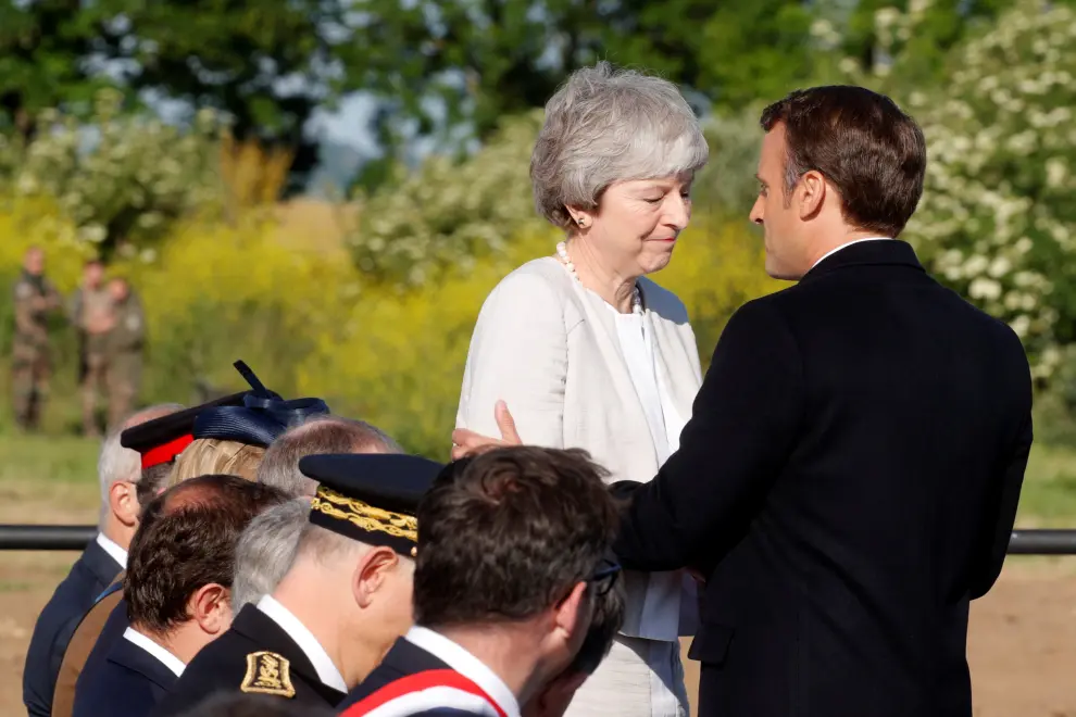 French President Emmanuel Macron greets British Prime Minister Theresa May during a Franco-British ceremony for the laying of the first stone of a British memorial in Ver-Sur-Mer as part of ceremonies to mark the 75th anniversary of D-Day landings in Normandy, France, June 6, 2019. REUTERS/Philippe Wojazer/Pool [[[REUTERS VOCENTO]]] DDAY-ANNIVERSARY/UK-FRANCE