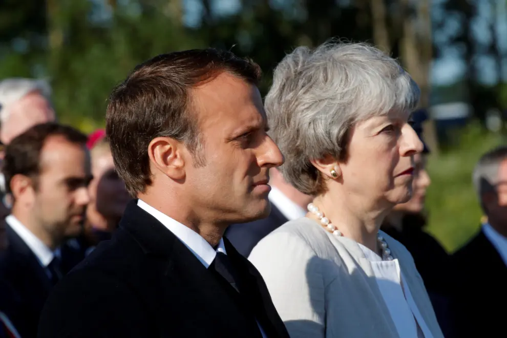 French President Emmanuel Macron greets British Prime Minister Theresa May during a Franco-British ceremony for the laying of the first stone of a British memorial in Ver-Sur-Mer as part of ceremonies to mark the 75th anniversary of D-Day landings in Normandy, France, June 6, 2019. REUTERS/Philippe Wojazer/Pool [[[REUTERS VOCENTO]]] DDAY-ANNIVERSARY/UK-FRANCE