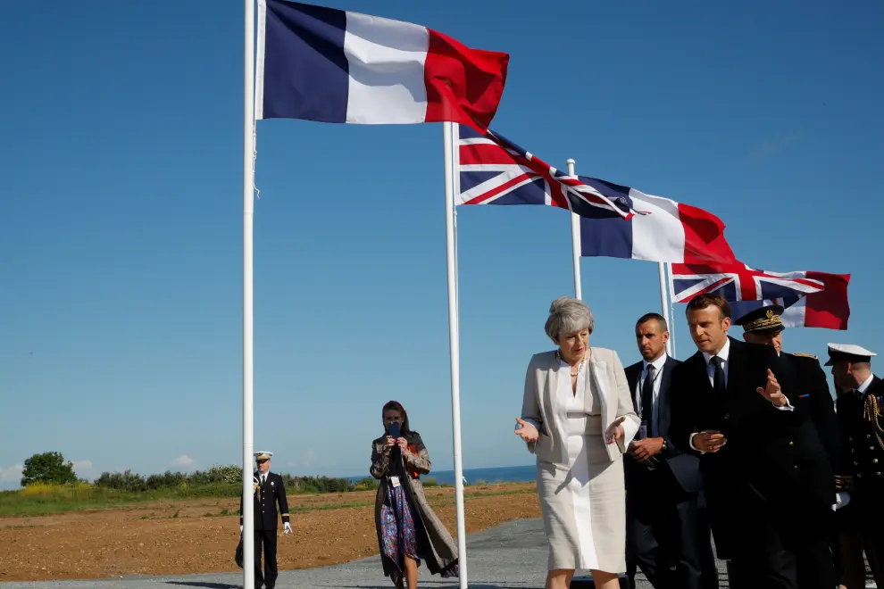 French President Emmanuel Macron and British Prime Minister Theresa May leave after a Franco-British ceremony for the laying of the first stone of a British memorial in Ver-Sur-Mer as part of ceremonies to mark the 75th anniversary of D-Day landings in Normandy, France, June 6, 2019. REUTERS/Philippe Wojazer/Pool [[[REUTERS VOCENTO]]] DDAY-ANNIVERSARY/UK-FRANCE