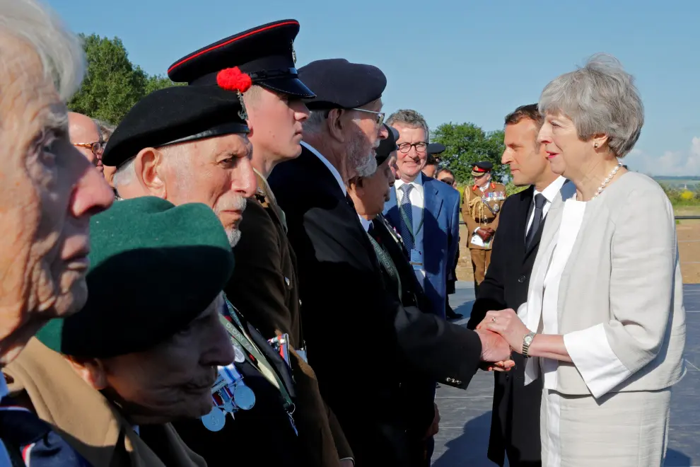 French President Emmanuel Macron and British Prime Minister Theresa May greet officials after a Franco-British ceremony for the laying of the first stone of a British memorial in Ver-Sur-Mer as part of ceremonies to mark the 75th anniversary of D-Day landings in Normandy, France, June 6, 2019. REUTERS/Philippe Wojazer/Pool [[[REUTERS VOCENTO]]] DDAY-ANNIVERSARY/UK-FRANCE