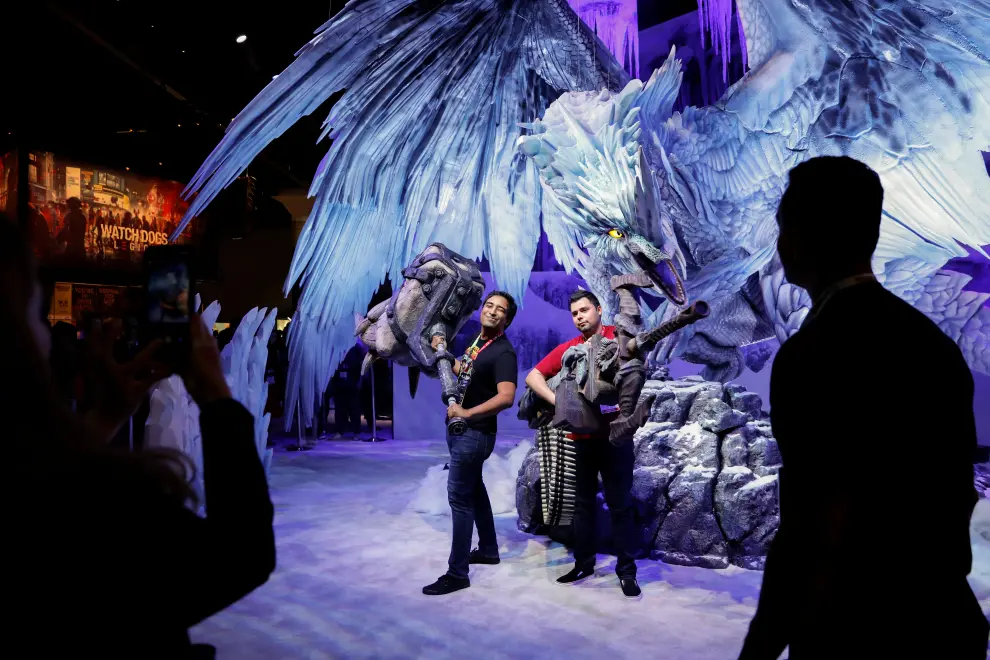Attendees pose at a large sculpture display as they attend opening day of E3, the annual video games expo revealing the latest in gaming software and hardware in Los Angeles, California, U.S., June 11, 2019.  REUTERS/Mike Blake [[[REUTERS VOCENTO]]] GAMING-E3/OPENING