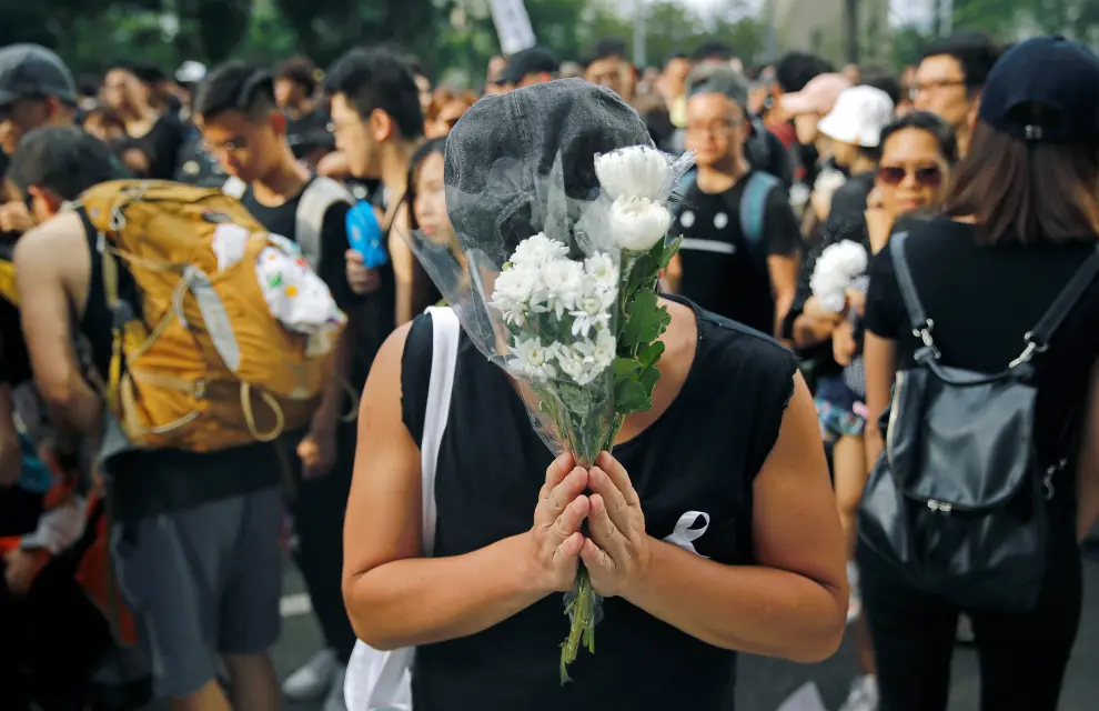 Protesters pay honours to a man, who died after falling from a scaffolding at the Pacific Place complex while protesting, during a demonstration demanding Hong Kong's leaders to step down and withdraw the extradition bill, in Hong Kong, China, June 16, 2019. REUTERS/Thomas Peter [[[REUTERS VOCENTO]]] HONGKONG-EXTRADITION/