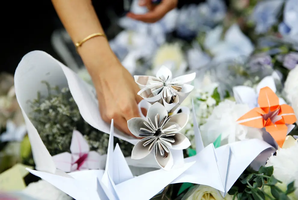 A protester holds flowers as he pays honours to a man, who died after falling from a scaffolding at the Pacific Place complex while protesting, during a demonstration demanding Hong Kong's leaders to step down and withdraw the extradition bill, in Hong Kong, China, June 16, 2019. REUTERS/Thomas Peter [[[REUTERS VOCENTO]]] HONGKONG-EXTRADITION/