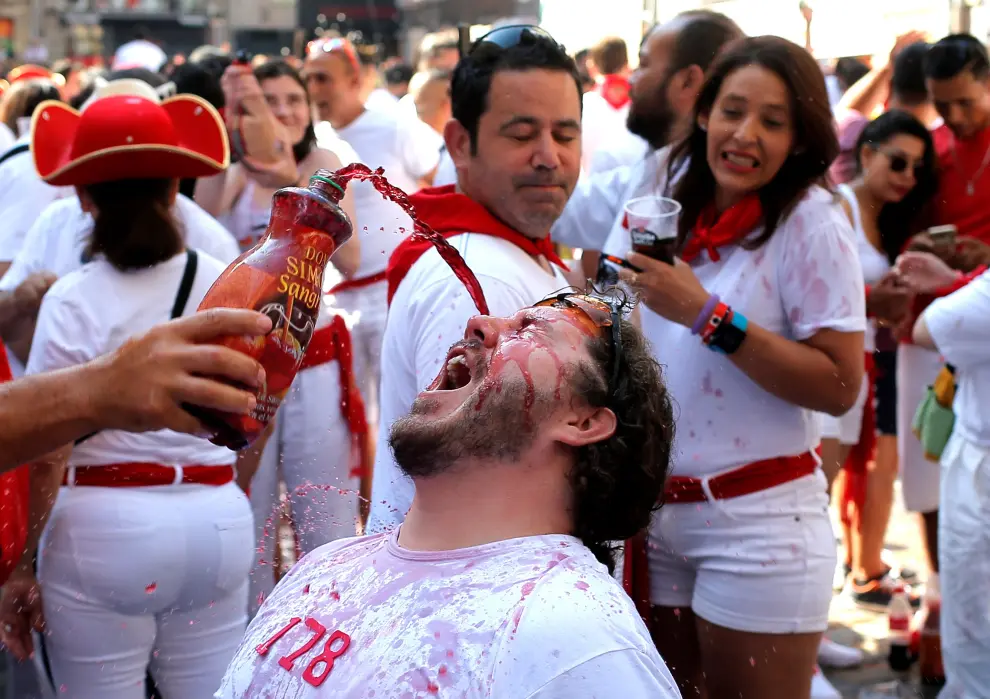 A man drinks wine from a bottle before the firing of 'chupinazo', which opens the San Fermin festival in Pamplona Spain, July 6, 2019. REUTERS/Jon Nazca [[[REUTERS VOCENTO]]] SPAIN-CULTURE/BULLS-CHUPINAZO