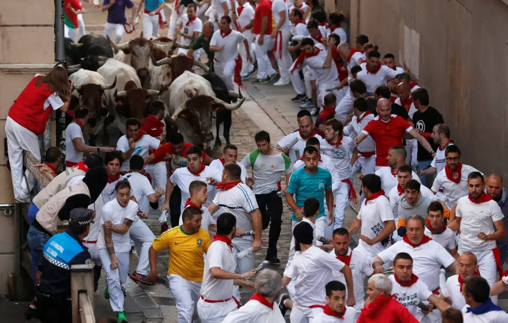 A reveller lays on the ground near bulls and steers during the running of the bulls at the San Fermin festival in Pamplona, Spain, July 11, 2019. REUTERS/Jon Nazca [[[REUTERS VOCENTO]]] SPAIN-CULTURE/BULLS
