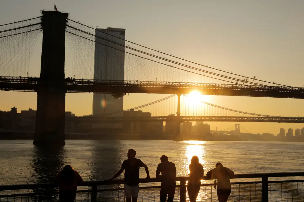 A man casts his line out as he goes fishing under the Brooklyn Bridge at sunrise as a heatwave continues to affect the region in New York, U.S., July 21, 2019. REUTERS/Andrew Kelly [[[REUTERS VOCENTO]]] USA-WEATHER/