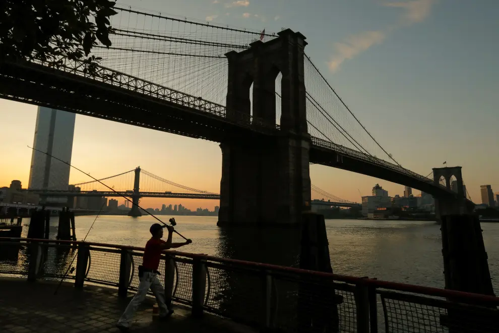 A man casts his line out as he goes fishing under the Brooklyn Bridge at sunrise as a heatwave continues to affect the region in New York, U.S., July 21, 2019. REUTERS/Andrew Kelly     TPX IMAGES OF THE DAY [[[REUTERS VOCENTO]]] USA-WEATHER/